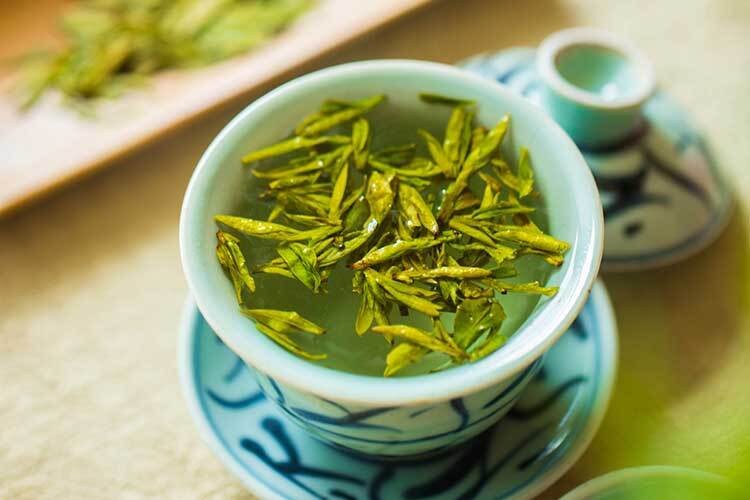 都市梧桐街区茶室里,白瓷茶具与倒茶动作